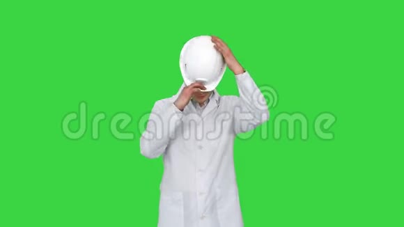 穿着白色长袍戴着安全帽戴着眼镜的科学家工程师用他的眼睛在绿色滑稽动作视频的预览图