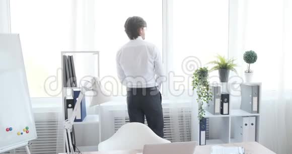坐在办公室笔记本电脑上工作的商人视频的预览图
