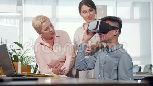 同事用3dvr眼镜看年轻商人视频的预览图