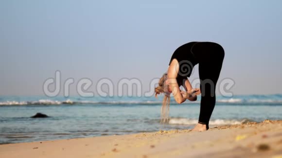 美丽的头发女人在沙滩上练习呼吸瑜伽视频的预览图