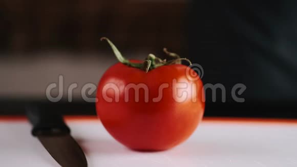 一个新鲜的西红柿正在用刀切视频的预览图