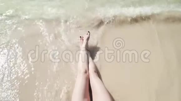 女人双腿被泡沫般的海浪拍打着视频的预览图