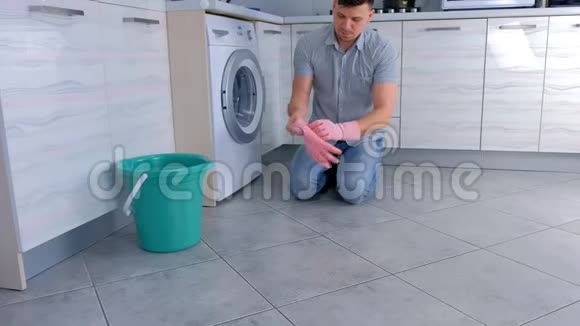 快乐男人戴上橡胶手套清洁厨房视频的预览图
