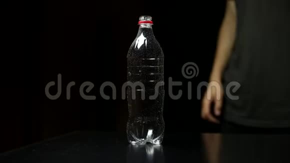 年轻的现代人拒绝一次性塑料瓶并选择可重复使用的钢热水瓶在黑色工作室背景视频的预览图