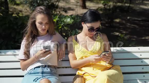 两个年轻女孩看着手机然后开始看书视频的预览图