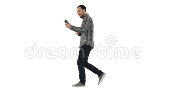 休闲技术通信和人的概念年轻人在白色行走时使用和调用智能手机视频的预览图
