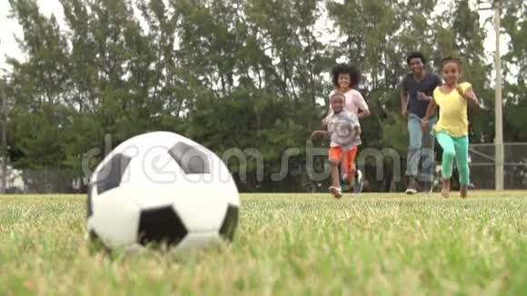 家庭在公园玩足球的慢动作序列视频的预览图