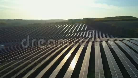 空中无人机镜头日落秋季太阳电池板农场上方的低空飞行视频的预览图