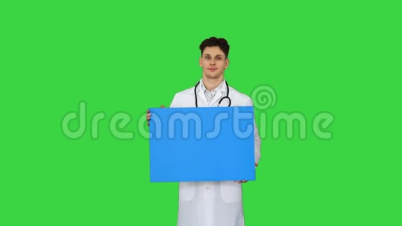 微笑的男医生戴着听诊器在绿色屏幕上举着空白海报Chroma键视频的预览图