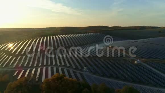 空中无人机镜头秋天日落时分从太阳能电池板农场上空飞离视频的预览图