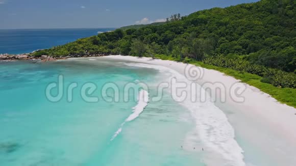 鸟瞰热带天堂海滩安塞可可在绿松石泻湖中白色的沙子和长长的浅白波浪滚动着视频的预览图