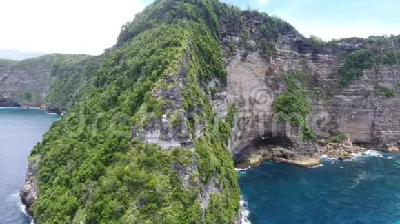 海岸线上被蓝色海水冲刷的山的影像片段视频的预览图