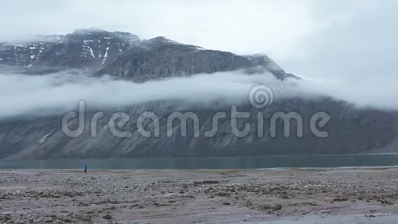 孤独的人站在湖和山的旁边视频的预览图