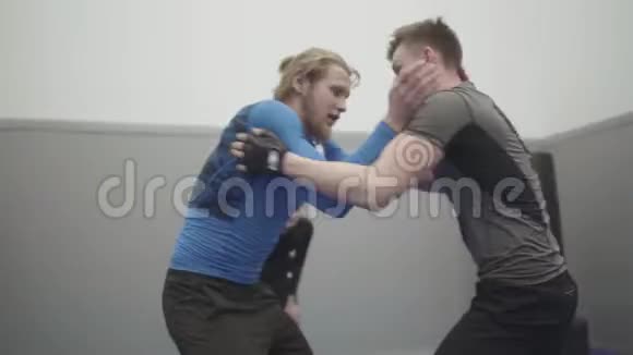 健身馆里摔跤的运动员们紧紧地在一起两名战士试图互相抓住一个人抓住对手他的手视频的预览图