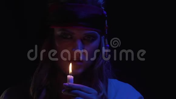昏暗的灯光接近一个海盗女人吹蜡烛4K视频的预览图