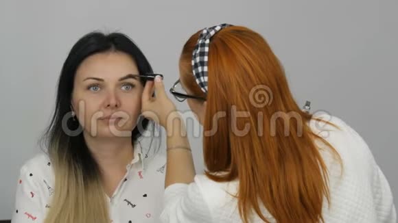 眉毛矫正采用专用眉毛和毛刷眼影化妆师将化妆应用于美丽的模特视频的预览图