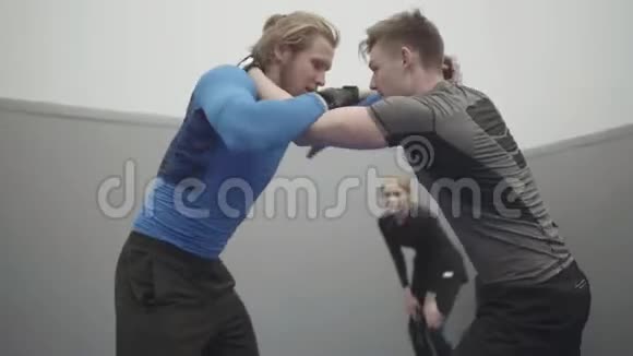 在健身房摔跤的职业男人都关门了两名战士试图互相抓住一个人抓住对手视频的预览图