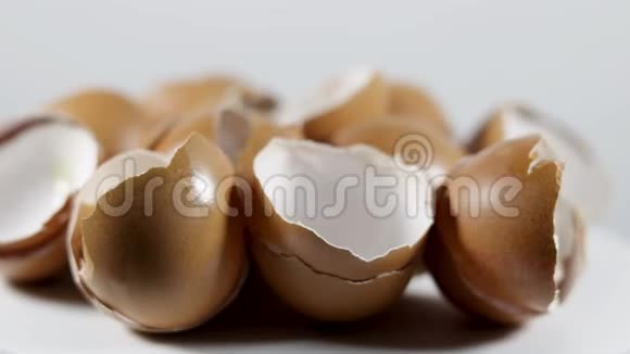 许多破碎的蛋壳在白色背景上呈棕色视频的预览图