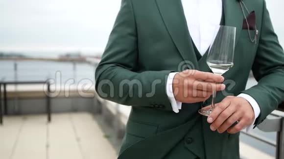 一个穿着漂亮昂贵西装的男人拿着一杯香槟视频的预览图
