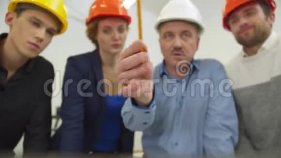 同事在头盔中倾听建筑师的声音在笔记本电脑屏幕上显示一个方案视频的预览图