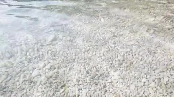 海底的灰色卵石透过清澈的水面上面有波纹视频的预览图