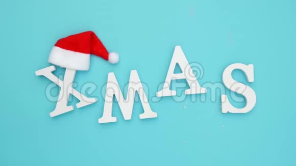 从红色圣诞老人帽的白色字母和蓝色背景雪蓝色背景概念圣诞快乐俯视图视频的预览图