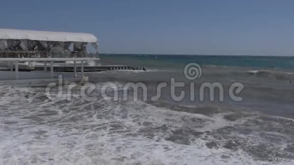 海上风暴巨浪撞击混凝土防波堤空的海边夏日餐厅视频的预览图