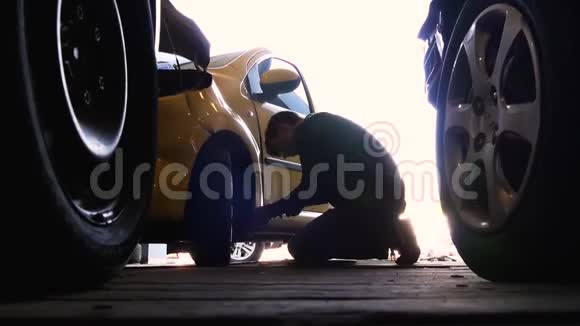 油漆凹痕修复拆除PDR一个年轻人用不锈钢钩子把车轮下的凹痕对齐视频的预览图