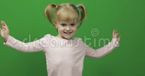 穿白色t恤的快乐小女孩可爱的金发孩子跳舞和做脸视频的预览图