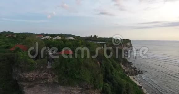巴厘岛巨大的悬崖和岩石海滩悬崖顶部的大型度假胜地4K视频的预览图