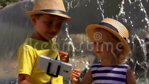 男孩和女孩在喷泉前自拍视频的预览图