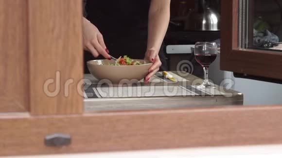年轻女性在厨房做饭做午餐准备餐混合新鲜沙拉生菜蔬菜一杯视频的预览图