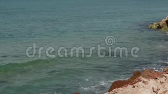 海浪慢慢地压向岩石海岸大镜头慢动作4K视频的预览图