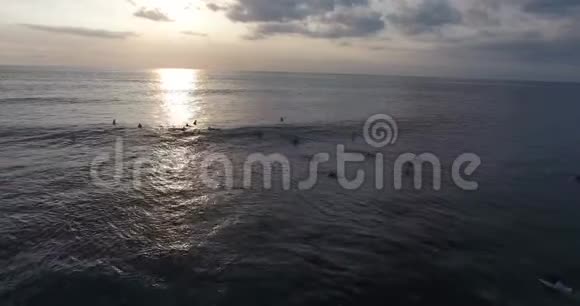 在波涛汹涌的海面上冲浪许多人在五彩缤纷的日落中乘风破浪视频的预览图