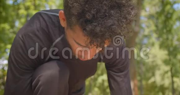 年轻强壮的非裔美国男性慢跑者准备在公园户外跑步的特写镜头视频的预览图