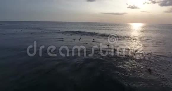 美丽的波浪海洋五彩缤纷的日落人们游泳冲浪空中射击视频的预览图