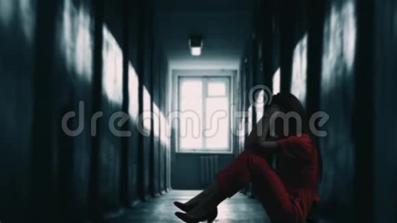 忧郁和沮丧的女人坐在黑暗的走廊里有背光和镜头照明悲伤的心情感到疲倦视频的预览图