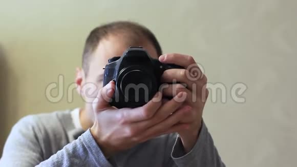年轻的摄影师拿着相机对着镜子视频的预览图