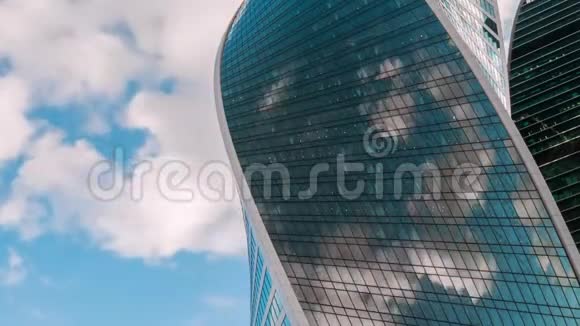 时间推移现代摩天大楼玻璃墙上移动的白云的反射视频的预览图