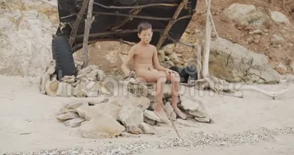 穴居人男子汉有趣的原始男孩户外进化生存概念外面冷静的男孩坐着视频的预览图