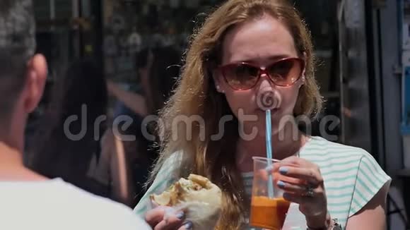 年轻的旅游女孩在市集吃街头食品视频的预览图