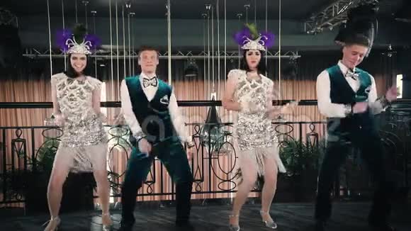 主题派对穿着闪闪发光的复古衣服的年轻人用手指在地板上跳舞视频的预览图