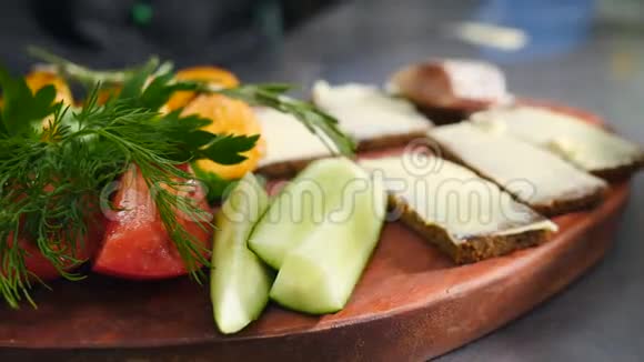 厨师做冷菜手套上的特写镜头用黄油把鲱鱼放在面包上黄瓜番茄和番茄视频的预览图