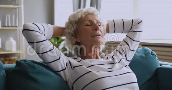 健康安详的老年妇女躺在沙发上呼吸新鲜空气视频的预览图