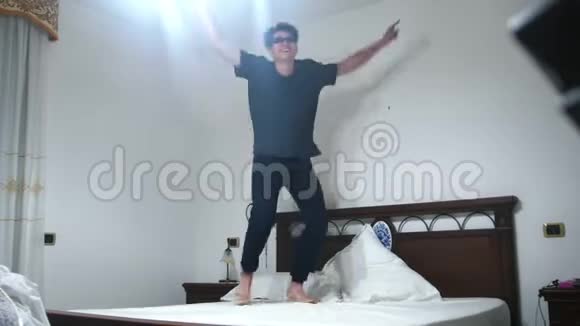 笑的男人在白色的床上跳着舞视频的预览图