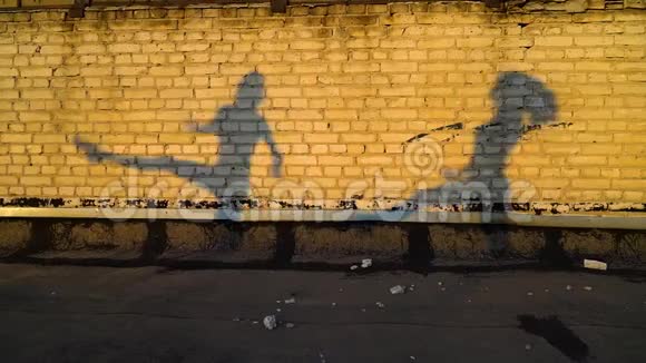 日落时女孩在砖墙上同时跳舞的剪影视频的预览图