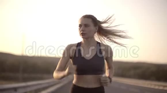 日落时分公路跑步运动女孩继续跑步尽管疲劳视频的预览图