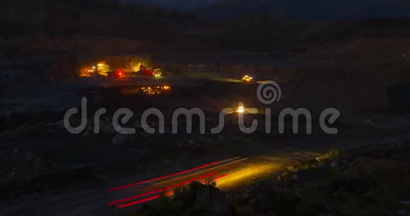 夜间作业挖掘机和卡车在采石场工作视频的预览图