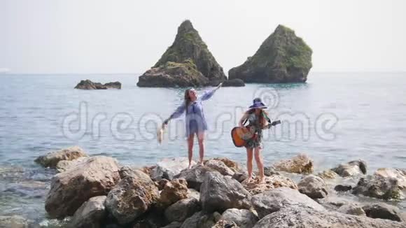 女人站在海里的岩石上跳舞弹吉他视频的预览图