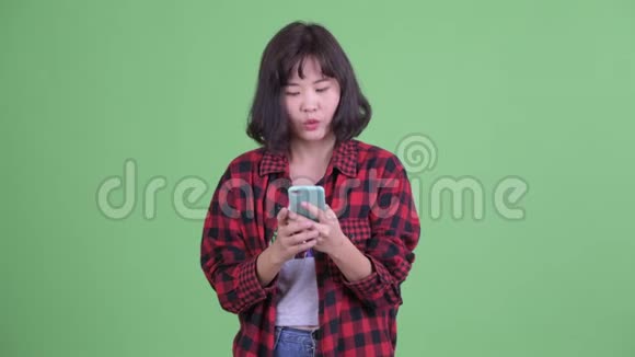 快乐的亚洲潮女使用电话得到好消息视频的预览图